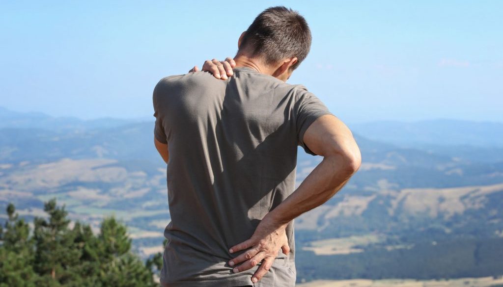 Back pain relief. Man hiker with back pain