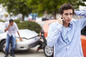 Adolescent driver placing a phone call following a traffic collision. 