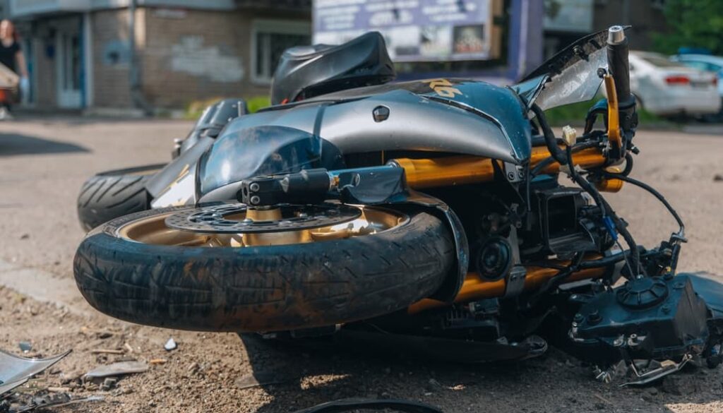 Motorcycle down, close-up after severe collision. Damaged bike highlights a serious traffic accident.