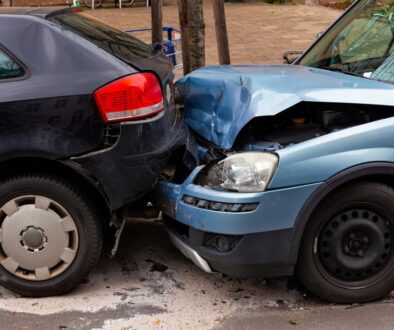 Two vehicles exhibiting metal damage following a rear-end collision.