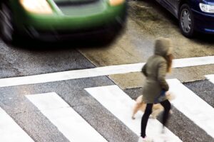 A dangerous situation at a city street crosswalk with people. 