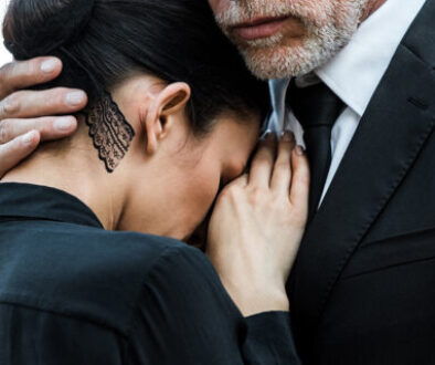 Tulsa wrongful death attorney supporting a grieving woman at a funeral.