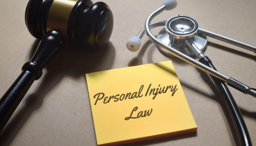 A gavel, stethoscope, and a yellow note with "Personal Injury Law" written on it, symbolizing the legal and medical aspects of personal injury cases.