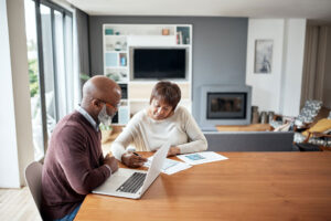 Older couple reviewing bills and paperwork together at home