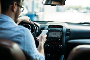 Driver using a smartphone behind the wheel while in traffic