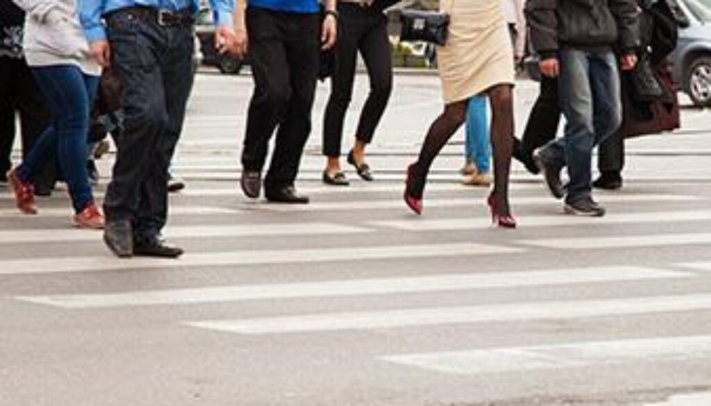 Pedestrians crossing a busy Tulsa street near a crosswalk, used by a Tulsa pedestrian injury attorney to highlight accident risks