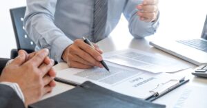 Two people reviewing an insurance policy document during a car accident claim