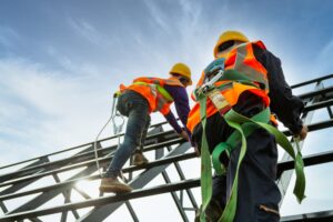 Construction workers at height wearing safety harnesses—representing high-risk injury cases handled by experienced Tulsa personal injury lawyers.