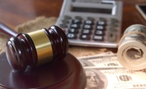 Gavel, cash, and calculator representing legal costs after a motorcycle accident