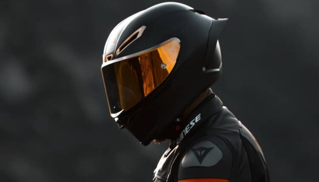 Close-up of motorcyclist wearing a full-face helmet and safety gear