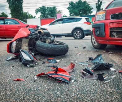 Red motorcycle lying on its side in the street after a crash with a white compact car in Oklahoma.