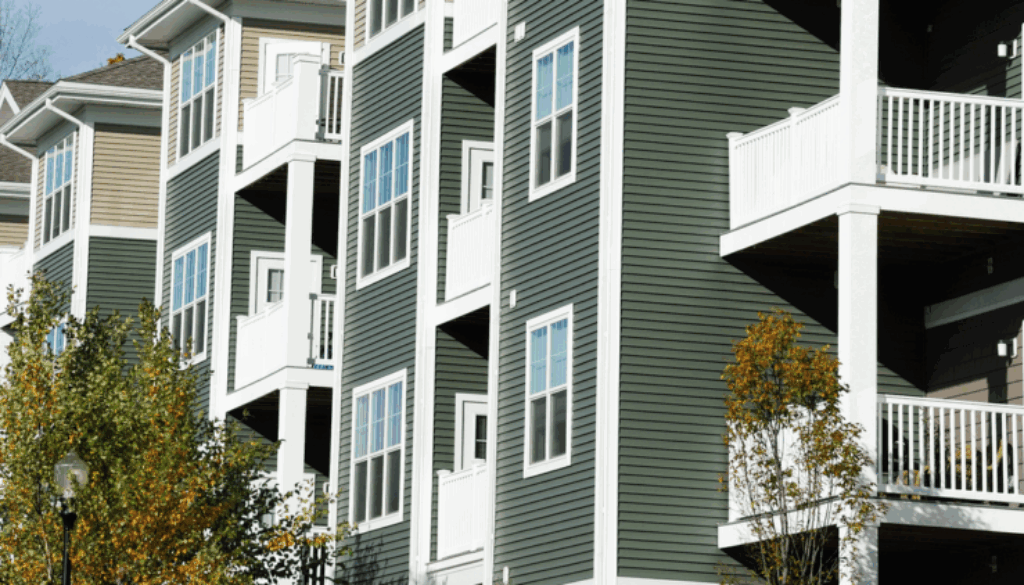 Exterior of a mid-rise apartment complex in Oklahoma with siding, balconies, and fall trees