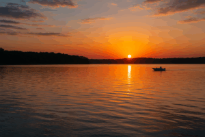 A peaceful Oklahoma lake at sunrise with gentle ripples and a distant boat.