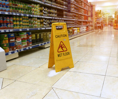 Wet floor caution sign in a grocery store aisle, representing common types of premises liability accidents
