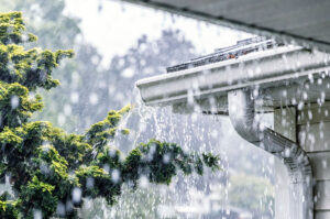 Heavy rain flooding a home’s gutter system during a storm