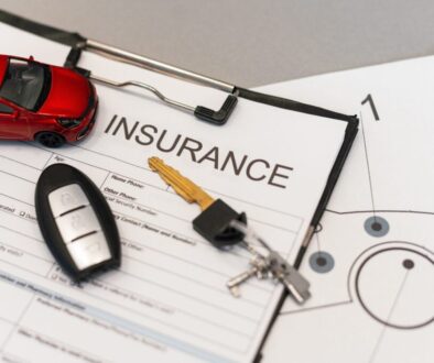 Auto insurance policy form with car key and miniature car