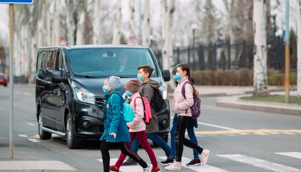 Children crossing at a marked crosswalk while a car yields in a Tulsa school zone