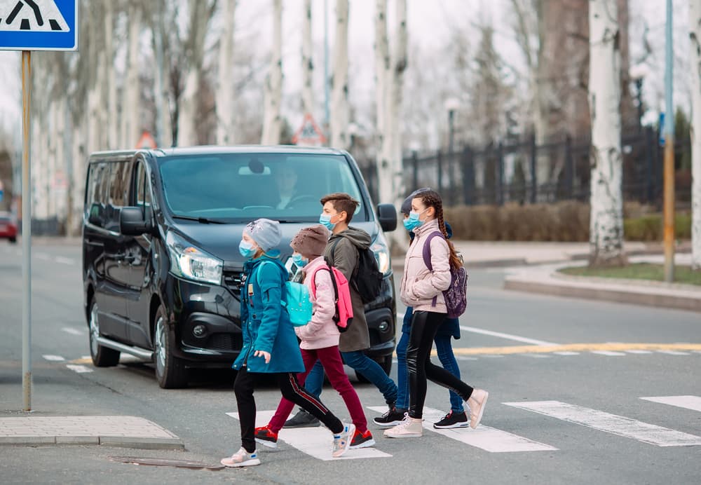 Children crossing at a marked crosswalk while a car yields in a Tulsa school zone