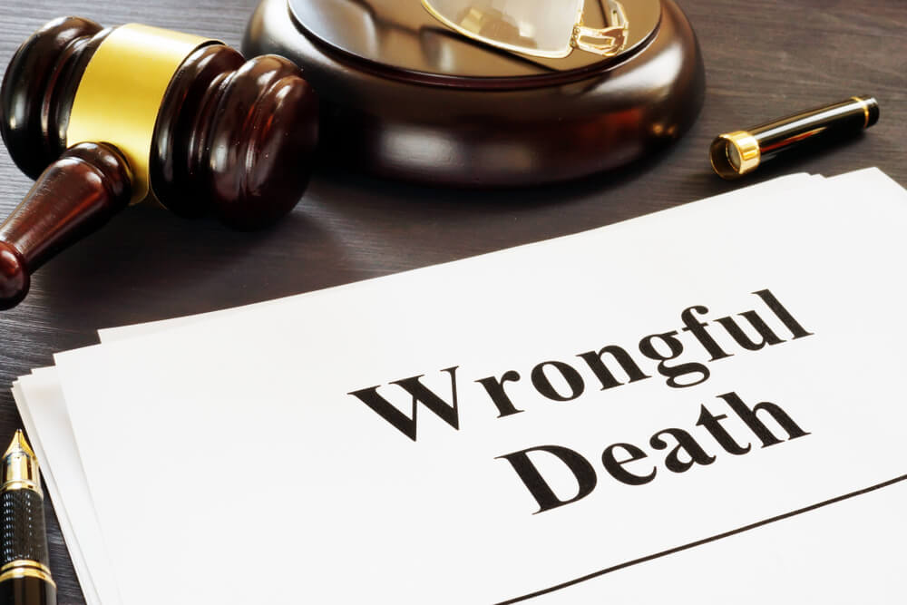 Legal document labeled “Wrongful Death” beside a judge’s gavel and reading glasses on a desk